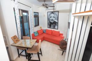 ein Wohnzimmer mit einem roten Sofa und einem Tisch in der Unterkunft Bella Luna Beach Condo #227487 in West End