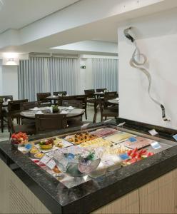 a buffet with many different types of food on a counter at Bristol Jaraguá Hotel Pampulha in Belo Horizonte