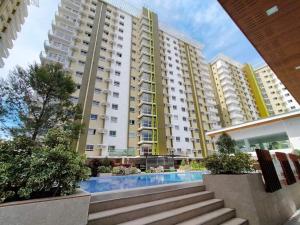 a large apartment building with a swimming pool in front of it at SoSe's Crib at Mesaverte Garden Residences in Cagayan de Oro