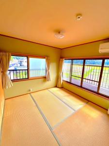 a room with two large windows and a room with mats at Villa KUMANO in Hongu