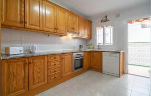 トレ・デル・マールにあるAmazing Home In Torre Del Mar With Wifiのキッチン(木製キャビネット、白い電化製品付)