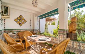 トレ・デル・マールにあるAmazing Home In Torre Del Mar With Wifiのパティオ(テーブル、椅子、窓付)