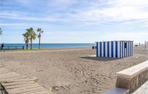 トレ・デル・マールにあるAmazing Home In Torre Del Mar With Wifiのヤシの木が茂る浜辺の青白小屋 +7枚の写真