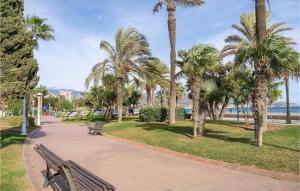 un parc avec des bancs, des palmiers et l'océan dans l'établissement 3 Bedroom Stunning Home In Torre Del Mar, à Torre del Mar