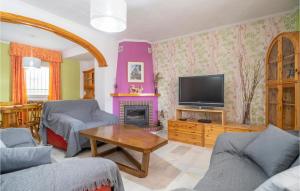 トレ・デル・マールにあるAmazing Home In Torre Del Mar With Wifiのテレビ、ソファ、テーブルのあるリビングルーム