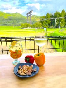 un plato de comida y una copa de vino en una mesa en Villa KUMANO, en Hongū