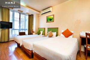 a hotel room with two beds and a tv at HANZ LakeView Hotel Hanoi in Hanoi