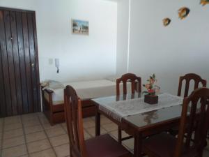 a room with a table and chairs and a bed at Torres a mais bela praia gaúcha in Torres +6 photos