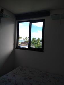 a bedroom with a window with a bed in it at Flat- maraca bech residence 2 in Ipojuca