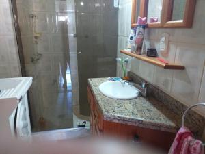 a bathroom with a sink and a shower and a sink at Torres a mais bela praia gaúcha in Torres