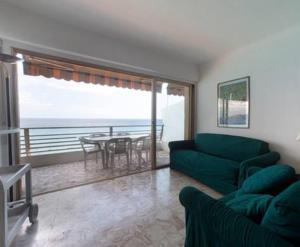 a living room with a couch and a table with a view at Flat Rossi in Menton