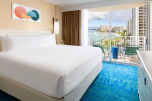 a hotel room with a bed and a view of the ocean at The Twin Fin Hotel in Honolulu