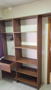 a closet with wooden shelves in a room at Apt 2 quartos, 5 pessoas em Container House in São Francisco do Sul