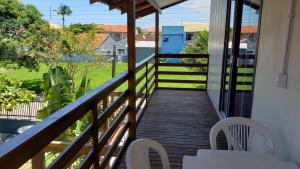 a balcony of a house with a wooden walkway at Apt 2 quartos, 5 pessoas em Container House in São Francisco do Sul