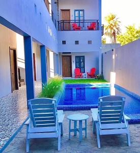 - deux chaises et une table à côté de la piscine dans l'établissement Hotel Casa Nodin, à Cuatrociénegas de Carranza