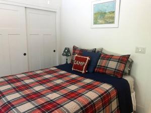 een slaapkamer met een bed met een geruite deken bij Slide Creek Ranch 1 mile to Bass Lake on 25 acres in Bass Lake