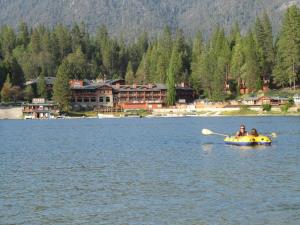 een paar mensen in een boot op een meer bij Slide Creek Ranch 1 mile to Bass Lake on 25 acres in Bass Lake