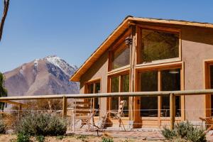 a house with a mountain in the background at Piuquenes Lodge - Cabañas Valle de Elqui in Horcon