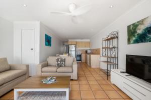 a living room with a couch and a tv at Apartment 8T in Lennox Head