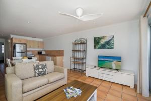 a living room with a couch and a flat screen tv at Apartment 8T in Lennox Head