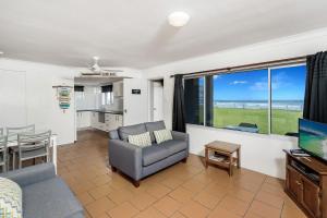 a living room with a couch and a table and a television at Apartment 4B in Lennox Head