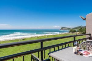 a table on a balcony with a view of the beach at Apartment 8T in Lennox Head