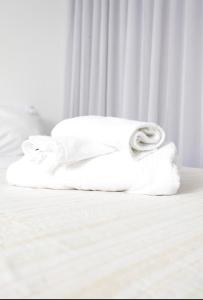 a stack of towels sitting on a bed at Apartamento 1009 in Goiânia