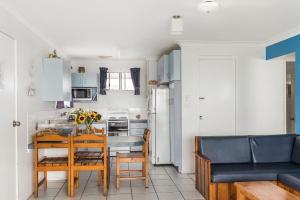 レノックス・ヘッドにあるAbsolute Beachfront Apartments 3Tのテーブルと椅子のあるキッチンとダイニングルーム