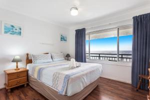 レノックス・ヘッドにあるAbsolute Beachfront Apartments 3Tのベッドがあり海が見える寝室