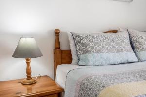 レノックス・ヘッドにあるAbsolute Beachfront Apartments 3Tのベッドとテーブルの上にランプが置かれた寝室 +8枚の写真