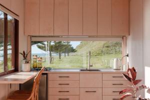 a kitchen with a sink and a large window at Tatapouri Bay in Gisborne