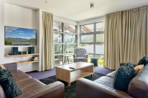 sala de estar con sofá y mesa en Absolute Lake Front Luxury- 2 bedroom apartment, en Queenstown