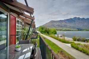 a balcony of a house with a view of the water at Absolute Lake Front Luxury- 2 bedroom apartment in Queenstown