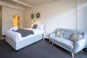 a bedroom with a bed and a couch at Studio Apartment - 5 Minutes to Hobart CBD - Free Parking - Free WIFI in Sandy Bay