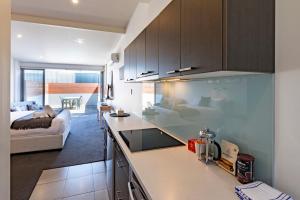 a kitchen with a counter top and a living room at Studio Apartment - 5 Minutes to Hobart CBD - Free Parking - Free WIFI in Sandy Bay