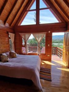 a bedroom with a bed and a large window at El Ensueño in Villa de Leyva