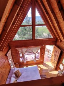 an attic bedroom with a large window in a log cabin at El Ensueño in Villa de Leyva