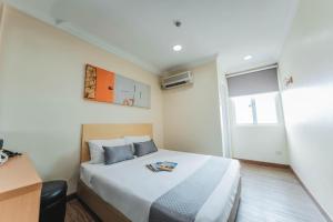 a hotel room with a bed and a window at Hotel 81 Joy in Singapore