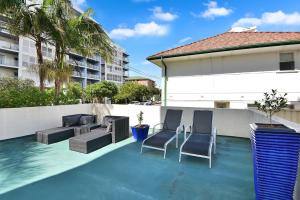 a swimming pool with two chairs and a couch on a building at Ocean Palms Unit 1 in The Entrance