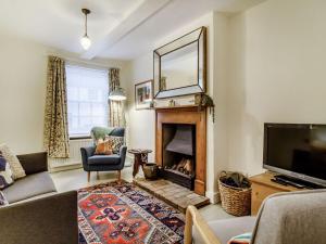 a living room with a fireplace and a television at The Yellow Cottage On The Hill in Framlingham