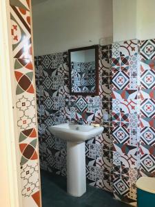baño con lavabo y pared de mosaico en Royal Resort en Weligama