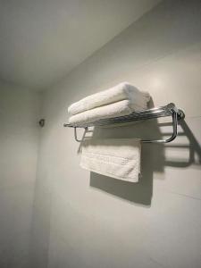 a towel rack with towels on it in a bathroom at New World Express Motel in Bintulu