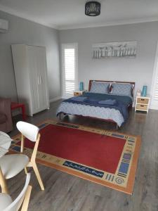 1 dormitorio con cama y alfombra roja en Southern Comfort, en Goolwa North