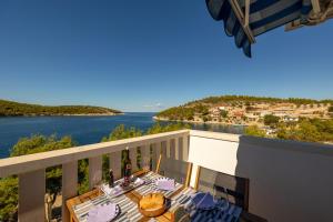 una mesa y sillas en un balcón con vistas al agua en Apartments Perfect place en Hvar
