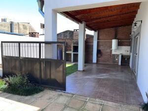 un patio al aire libre con una puerta de madera y una pared de ladrillo en Hermoso duplex en barrio cerrado en Posadas