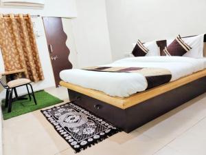 um quarto com uma cama, uma cadeira e um tapete em Homestayinn em Ahmedabad