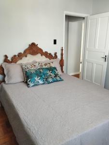 1 dormitorio con 1 cama con 2 almohadas en Apartamento encantador no centro c/ garagem cobert, en Serra Negra