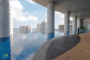a swimming pool on the roof of a building with columns at Encorp Marina Puteri Harbour by RR JBcity in Nusajaya