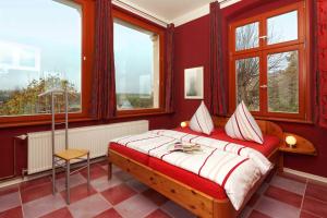 a bedroom with a bed with red walls and windows at Villa Maria Wohnung 06 in Ostseebad Koserow