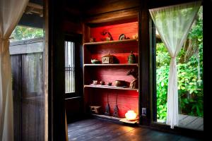 Habitación con pared roja y estante para libros. en Traditional house, Blue moon villa, 古民家 蒼月庵, en Kimitsu